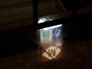 A still image of the reflection of a metro sign.